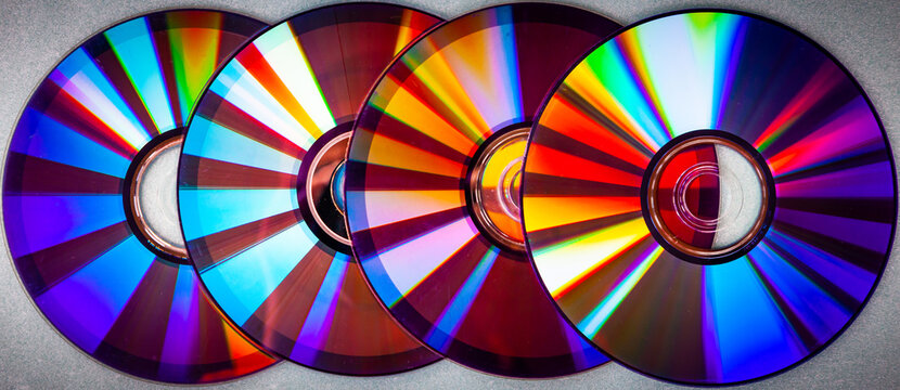 Music CDs with colored reflections on the surface. DVD discs.
