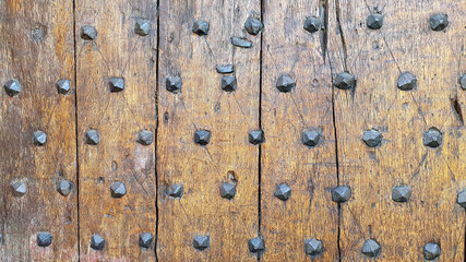 Close up of a medieval wooden door and iron rivets