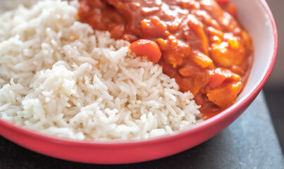 Home cooked king prawn curry on a bed of freshly steamed basmati rice with intentional seelctive focus, shallow depth of field and bokeh