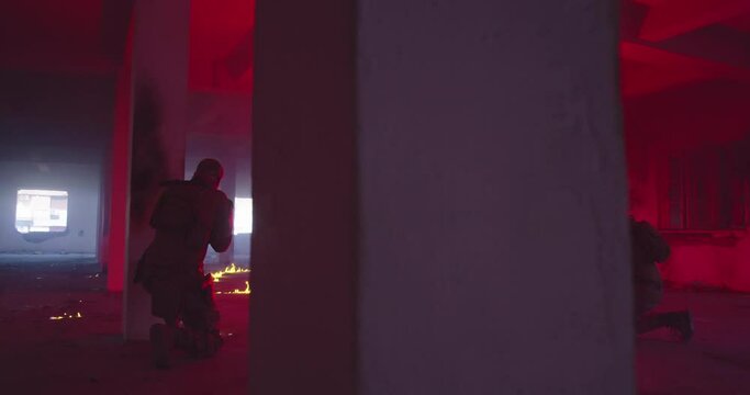 Masked Team of Armed Modern Warfare Soldiers Team Move in Tactical Formation in a Dark Urban Battlefield Indoors.Soldiers Squad with Rifles and Flashlights in action.