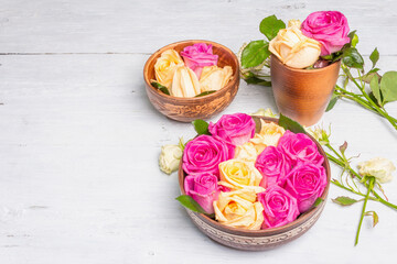 Obraz na płótnie Canvas Composition of fresh multicolored roses in kitchen utensil