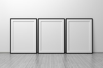 Mockup template of three A4 frames with thin black frame border standing next to wall on wooden floor