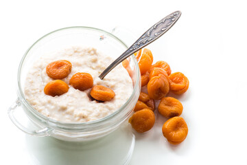 cooked boiled sweet oatmeal with dried apricots in a bowl