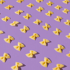 Flat lay pattern of farfalle pasta. Fun and bright food concept. Bow tie shaped macaroni.