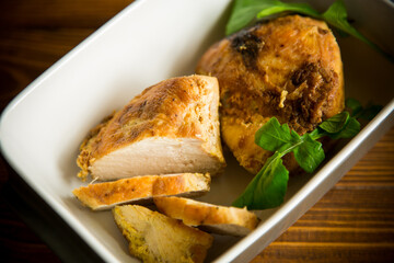 baked chicken fillet pieces with spices and herbs, in a ceramic form