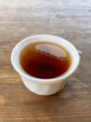 white cup of tea on wooden background