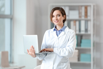 Female doctor using laptop in clinic
