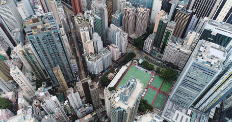 Top view aerial photo from flying drone of a developed Hong Kong city with modern skyscrapers with contemporary design. China town with business and financial centers and road with cars