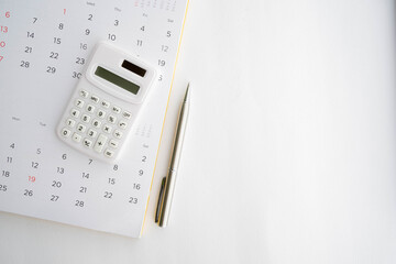 close up top view on calculator with calendar and pen on white background with copy space for business and financial activity monthly concept - obrazy, fototapety, plakaty