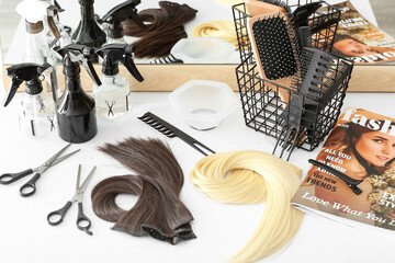 Barber's tools and strands of beautiful hair on table in beauty salon