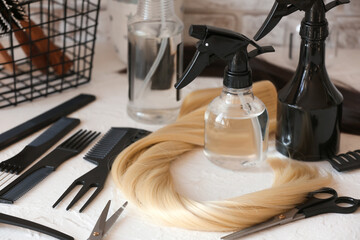 Barber's tools and strand of blonde hair on table in beauty salon