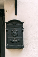 Old iron mailbox on a white facade