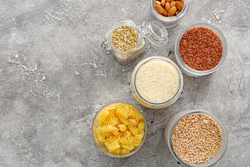Glass jars with different products on grunge background