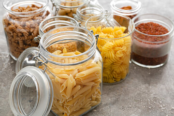 Glass jars with different products on grunge background, closeup