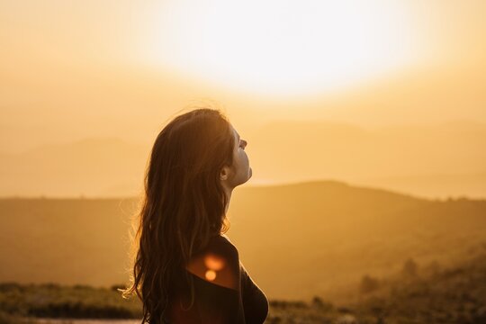 Carefree woman standing on hill and enjoying freedom