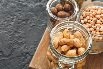 Glass jars with different products on dark background
