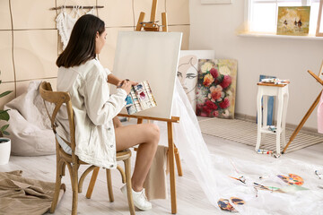 Young female artist waiting for inspiration in workshop