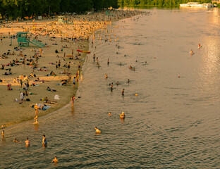 Top view from the bridge to the beach and a lot of people near the river in the city. Hydropark in...