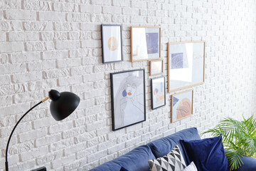 Stylish pictures hanging on brick wall