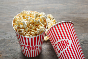 Buckets with tasty popcorn on wooden background