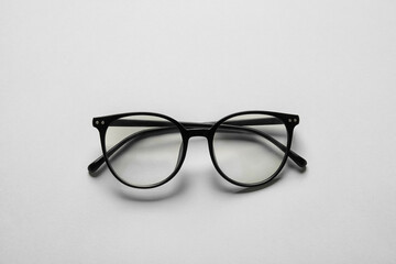 Stylish eyeglasses on light background