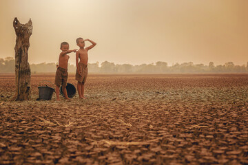 Climate change, Two Asian boys walking and searching for water on dry ground and sunset. Environment conservation and stop global warming concept
