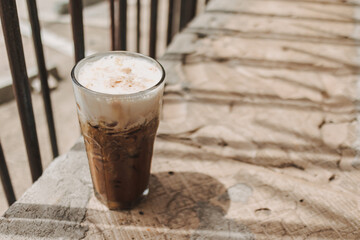 Iced cappuccino coffee drink in a tall glass. Concept of summer refreshment drink.
