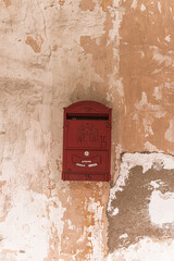 Czerwona skrzynka pocztowa na listy na tle starego budynku. - obrazy, fototapety, plakaty