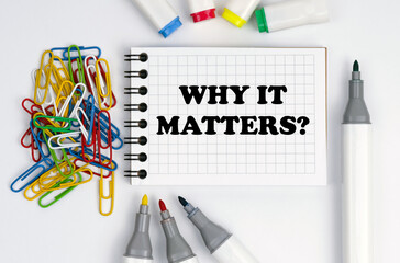 On the table are markers, paper clips and a notebook with the inscription - Why It Matters