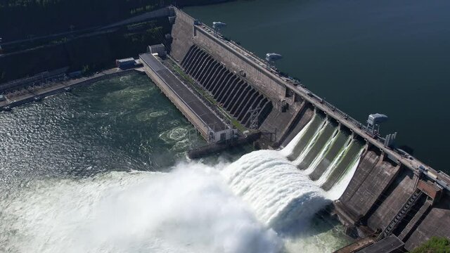 Hydroelectric dam on the river, water discharge from the reservoir, aerial footage