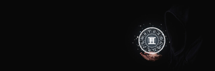 Female hands with palms holding glowing zodiac signs symbols in the dark. Banner © Alex