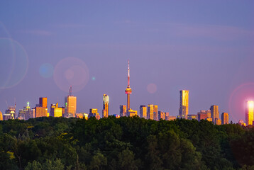 Fototapeta na wymiar Toronto skyline on a purple sky background with lens flare at sunset
