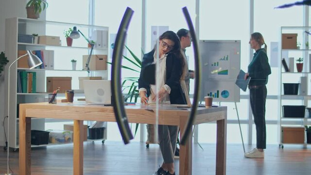A Successful Pregnant Businesswoman Has a Business Conversation on the Phone. A Young Pregnant Woman Works With Colleagues in a Comfortable Modern Office. The Concept of Motherhood, Business and Work.