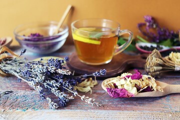 Herbal tea with lemon, dry petals of useful flowers on a wooden table
