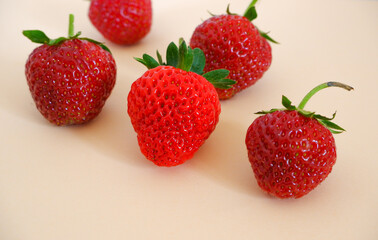 Fresh berries. Fresh juicy red strawberries on a pastel pink background with shadows. Close-up photo.
