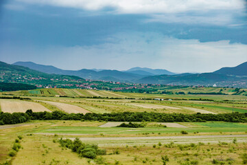 Fototapeta na wymiar Countryside green land panorama on a cloudy day