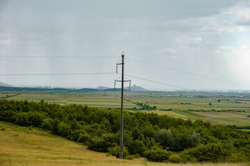 Powerline pillar in the forest and raining sky on countryside