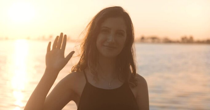 Attractive young woman is wave. Hand gestures, saying hi or bye. Youthful and friendly happy lady.
