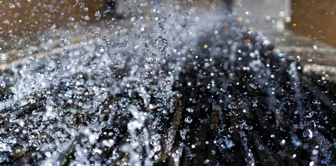 Water spatter drops of fountain on the wall in Berlin park. Macro photo of water spray of fountain