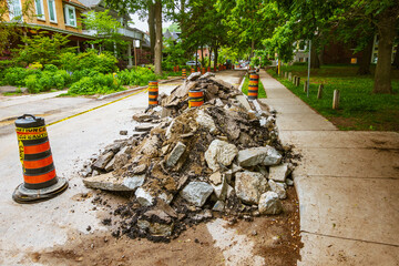 Torn up and piled asphalt paving on a residential street part  of water system repair project in a...