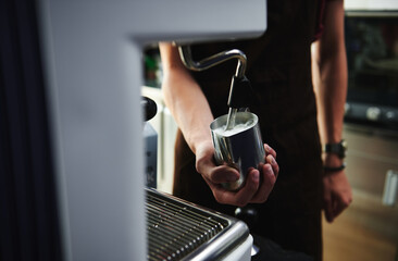 Close-up of making milk foam, whipping milk in professional steam coffee machine
