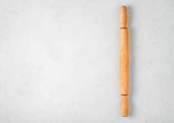 Wooden rolling pin on a gray background. Culinary background.