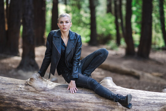Young Woman Sitting or Standing on Fallen Tree in a Redwood Grove