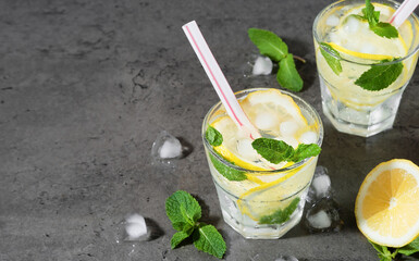 Glass of refreshing summer lemonade, top view. Cold natural drink with mint, ice and lemon wedges,...