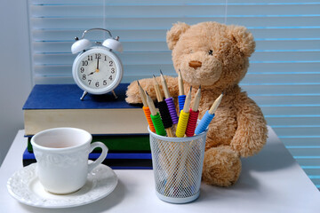 cup of coffee, cappuccino, white alarm clock against the background of blinds on the table, concept of tea time, break, be in time, finish things, be able to relax