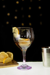 Coctel con hielo y limon en una mesa de cristal con luz