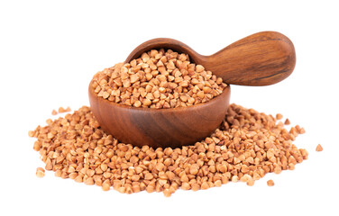 Roasted buckwheat grains in wooden bowl and spoon, isolated on white background. Dry brown buckwheat groats.