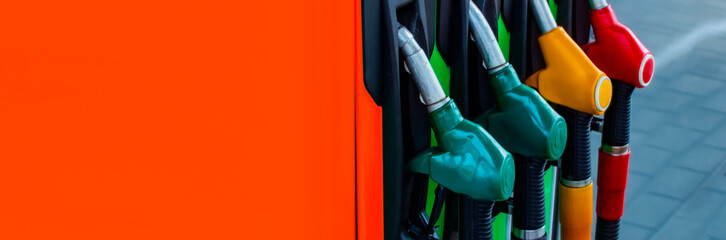 Gas station close-up with colored fuel hoses.