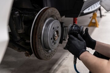 Car mechanic repairing car brakes in service