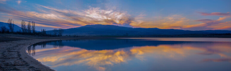 The reflected colors of the sunset in the dam. Panoramic view. Kyustendil, Bulgaraia